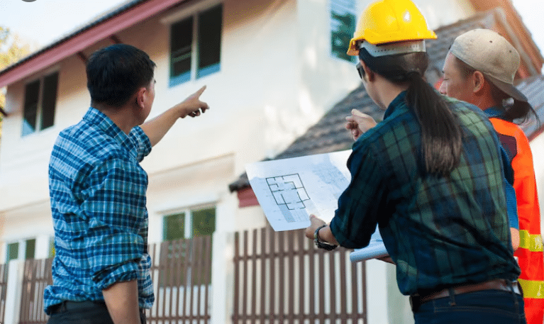 Construction team reviewing house plans on site