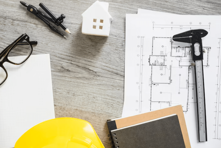 Construction blueprint with measuring tools and hard hat