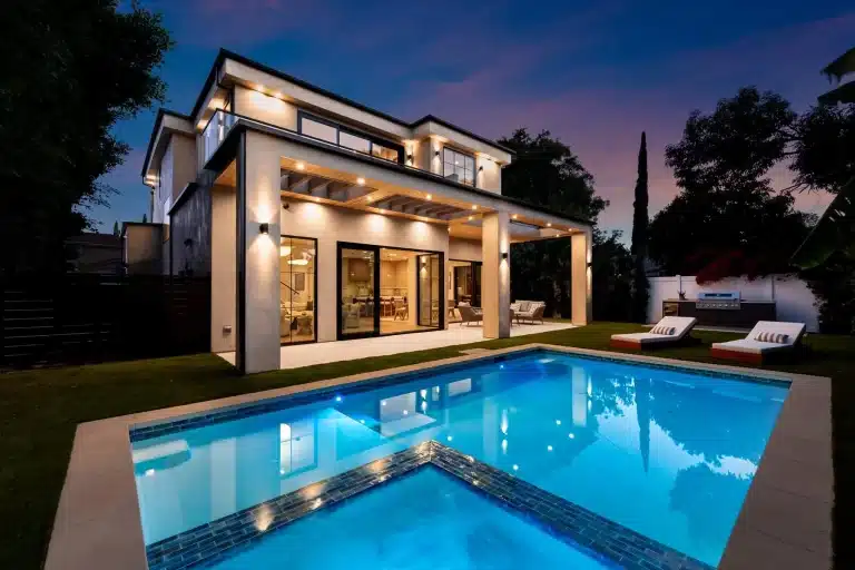 Luxury backyard pool illuminated at night