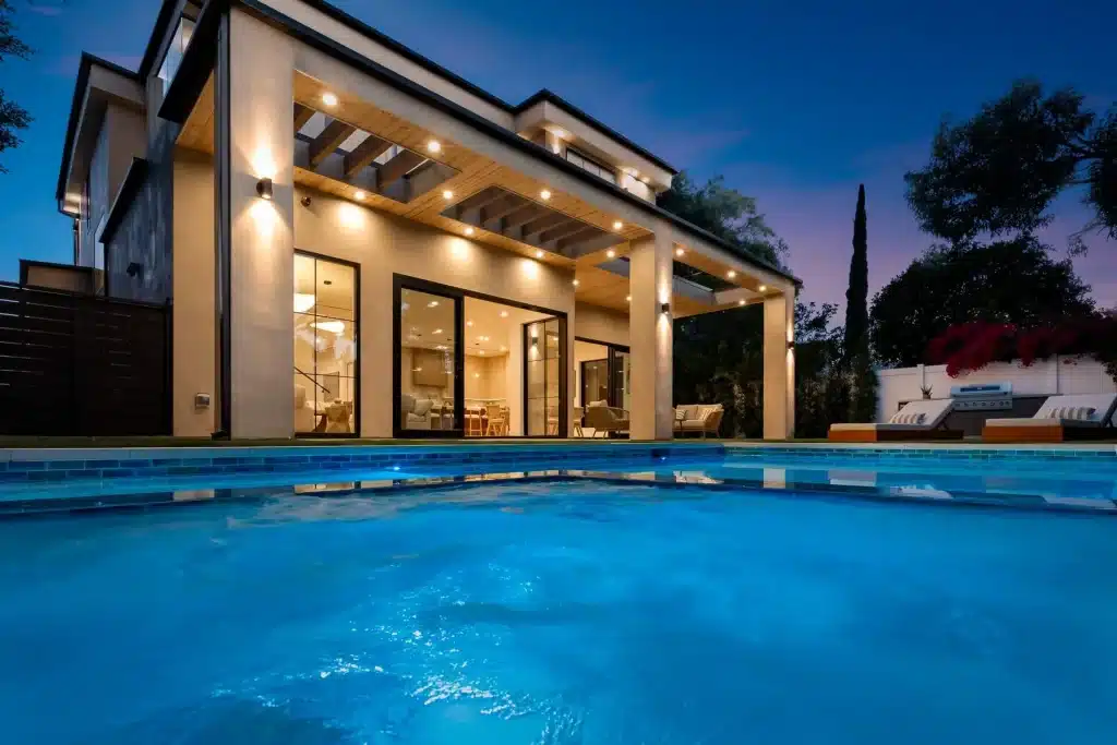 Luxury home viewed from illuminated swimming pool