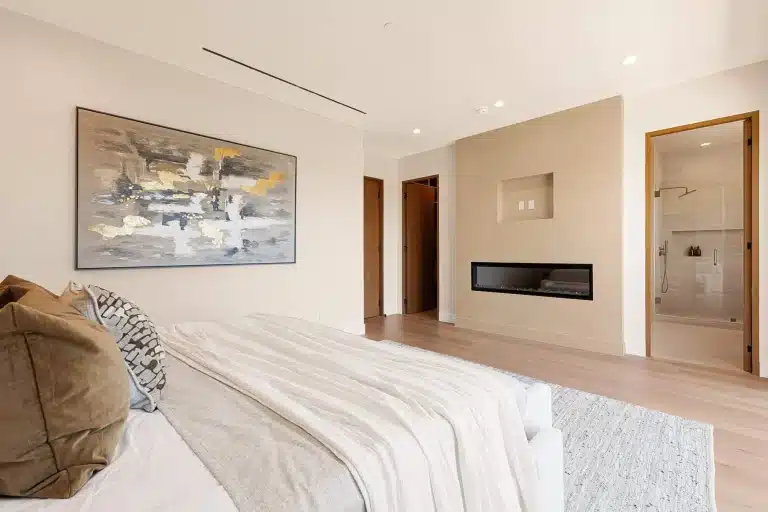 Luxury primary bedroom with modern fireplace