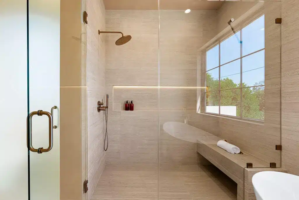 Frameless glass walk-in shower with built-in bench
