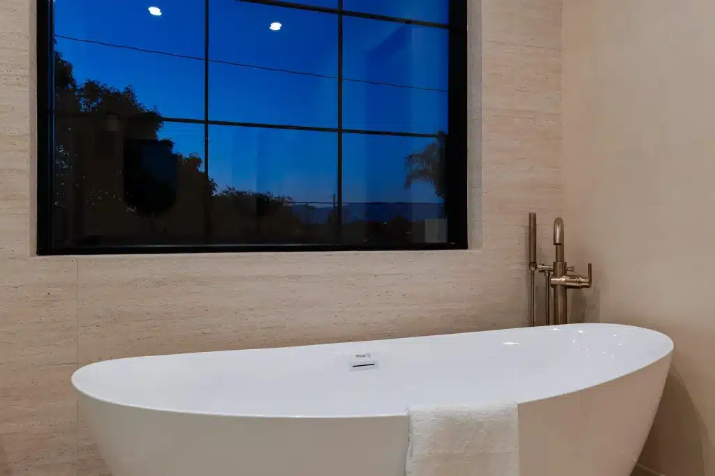 Luxury freestanding bathtub beside large picture window