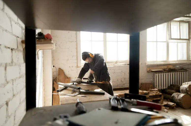 Metalworker cutting steel components in a workshop during a custom fabrication project.