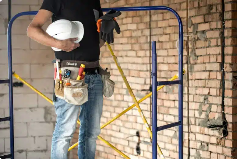 Construction contractor with safety equipment standing inside a residential renovation project.